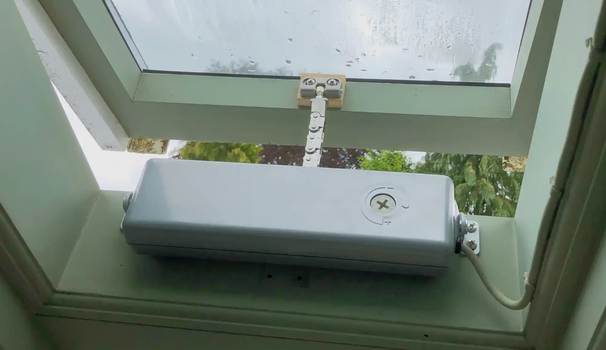 A Silver ACK4 mounted to a green timber roof lantern with a partially open window